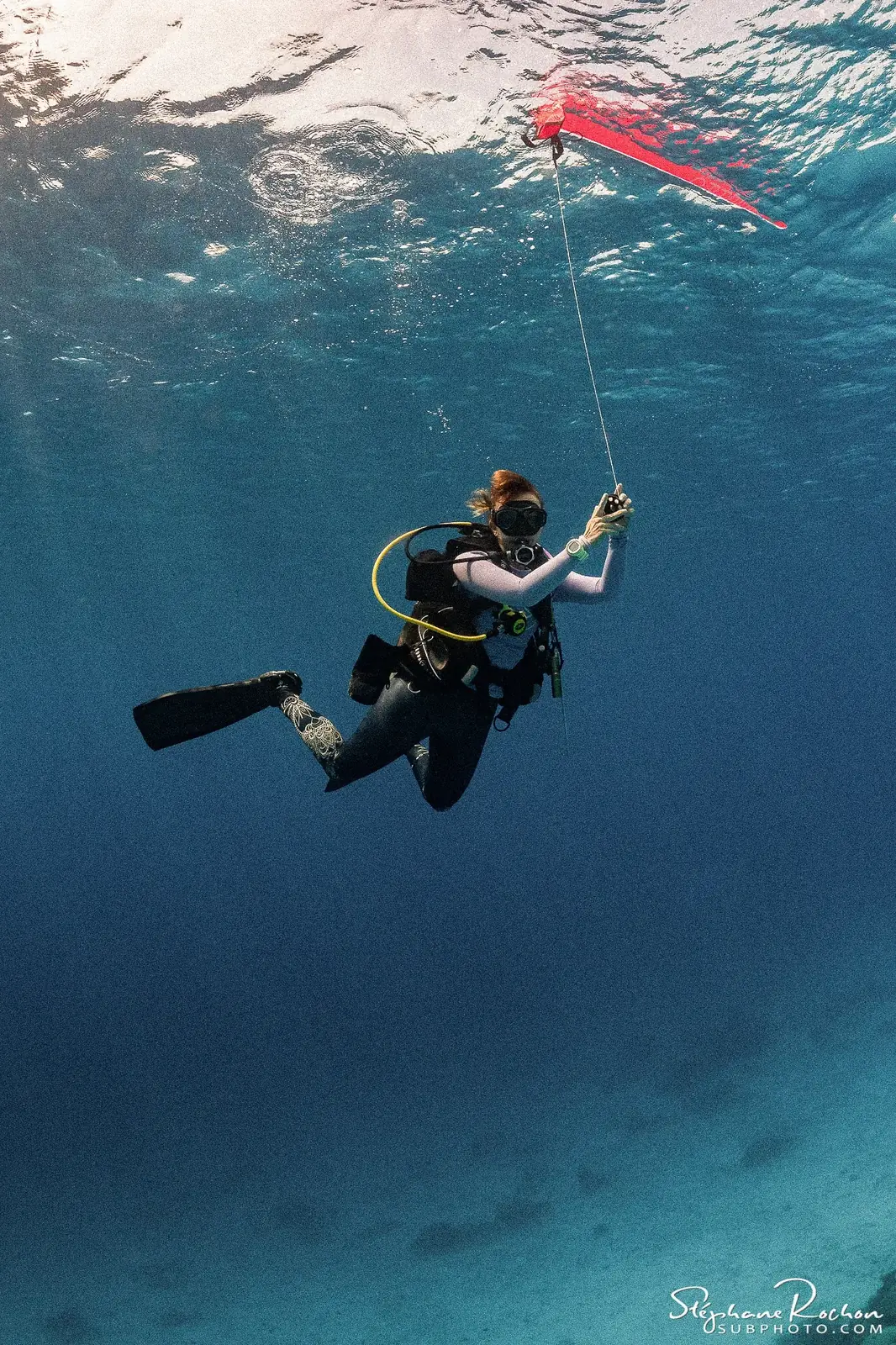 A diver deploying a surface marker buoy.