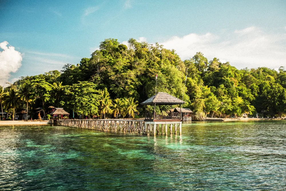 A stilted pavilion over turquoise water.