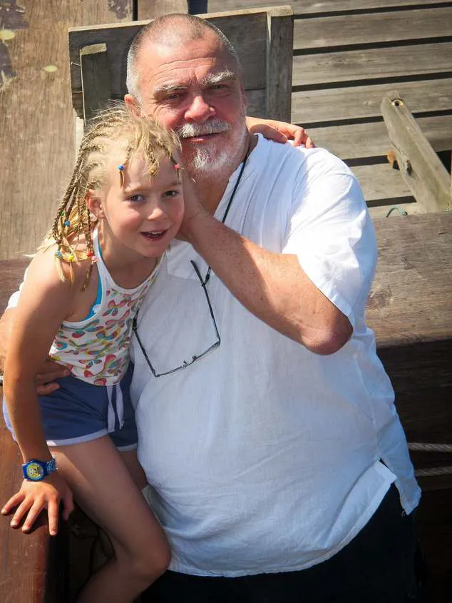 Michel with a young girl on a wooden deck