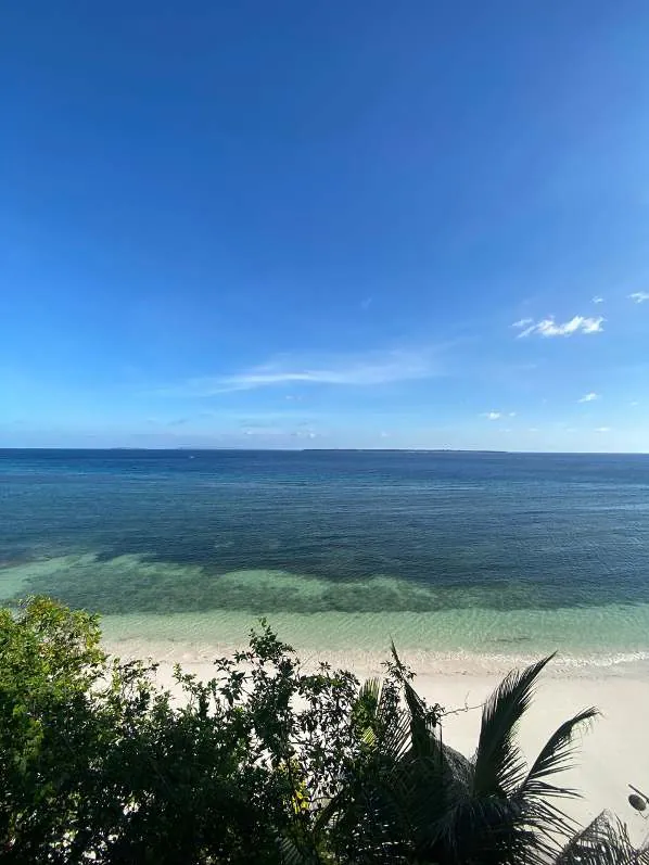 White sand beach and turquoise sea at Bira, seen through the trees