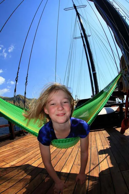 Young Camille lying in a green hammock on WAOW's deck