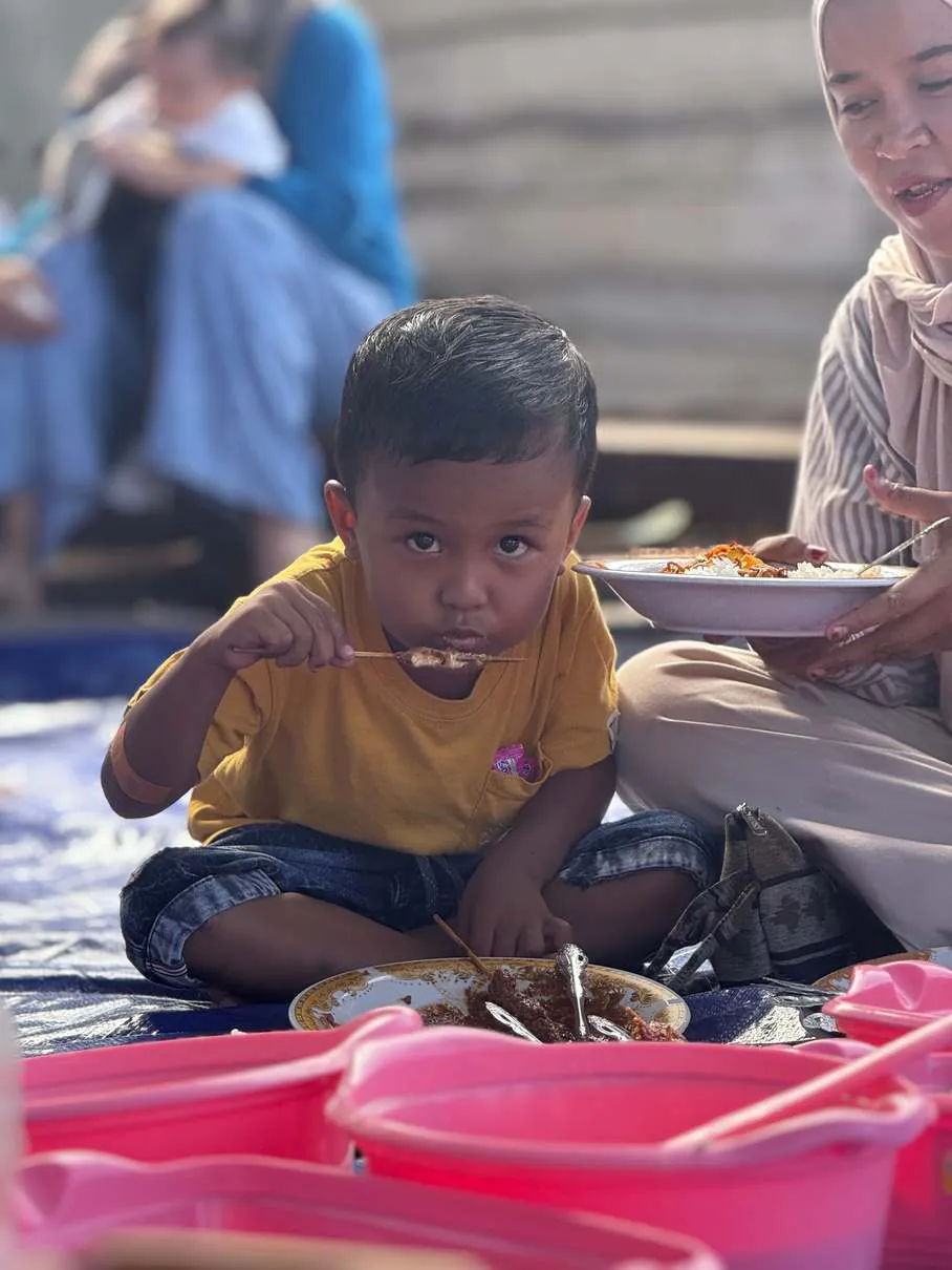 A young child eating at the communal feast
