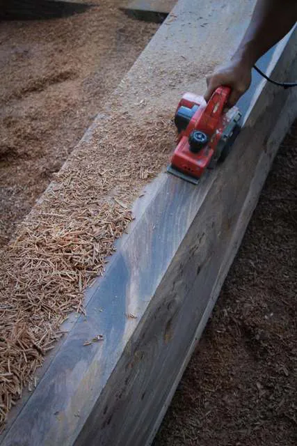 An electric planer shaping an ironwood beam