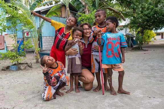 Wulan with a group of laughing village children