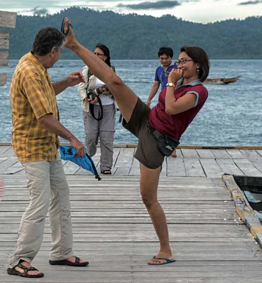 Wulan playfully high-kicking on a wooden jetty
