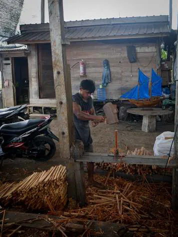 A carpenter shaping timber in the workshop