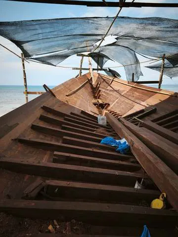 The bow section with its first planks under the shade nets