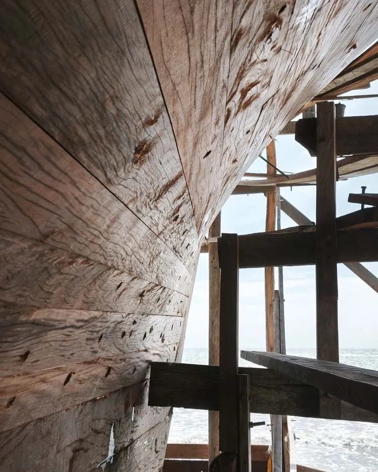 Close-up of the hull planking curving up into the scaffolding
