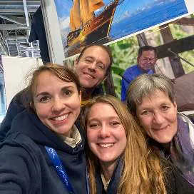 A selfie of smiling friends at the booth