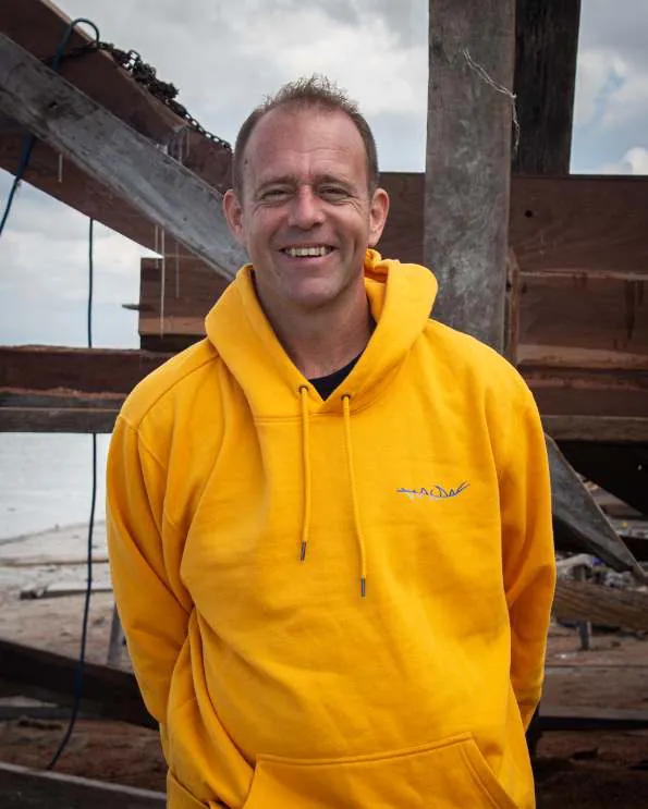 Portrait of Reto Schlaepfer in a yellow WAOW hoodie at the shipyard