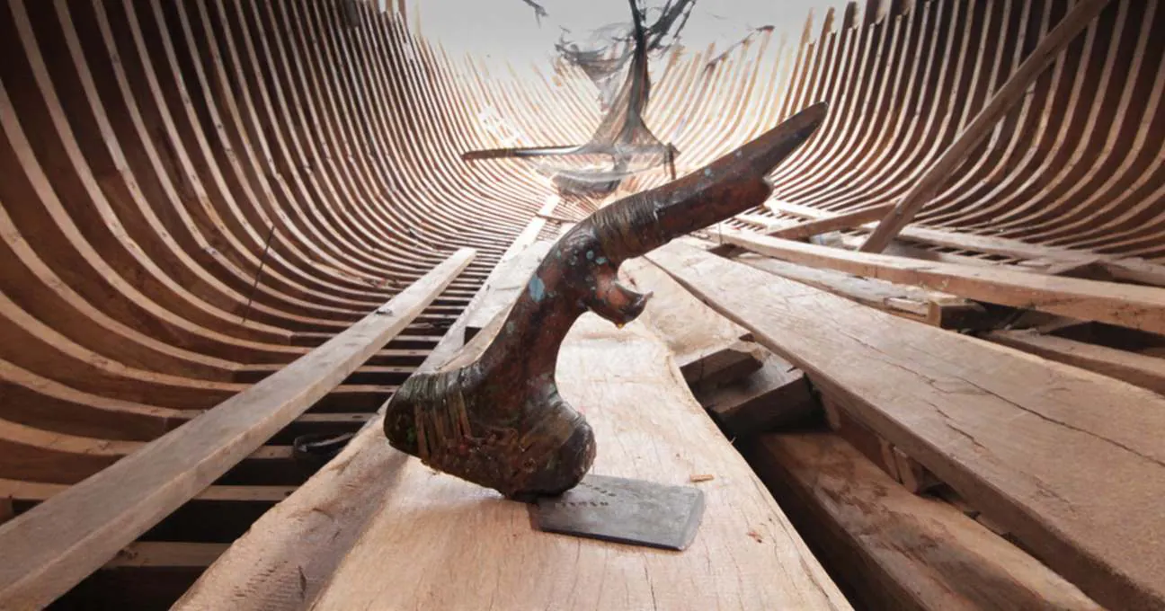 A traditional wooden plane resting on a plank inside the hull