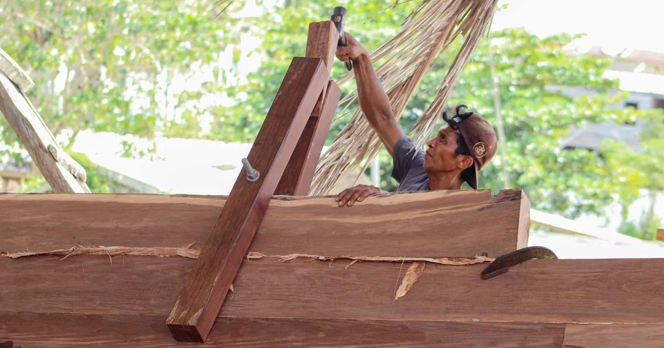 A shipbuilder fixing a clamp to hold planks together