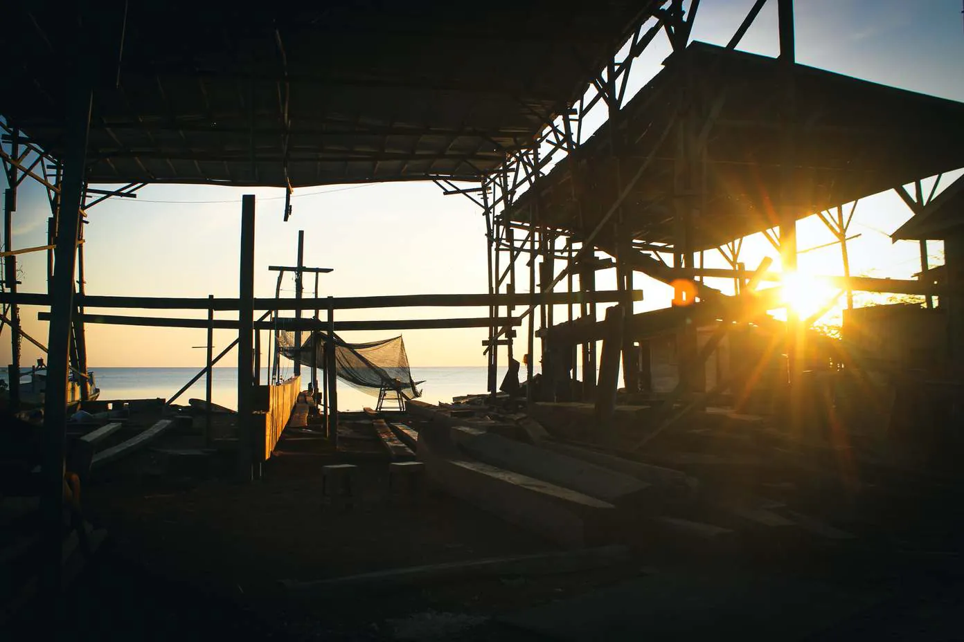 Sunlight shining through the shipyard shed and scaffolding at sunset