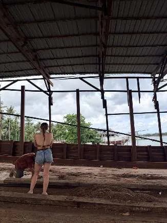 Camille standing on the hull under the shipyard roof
