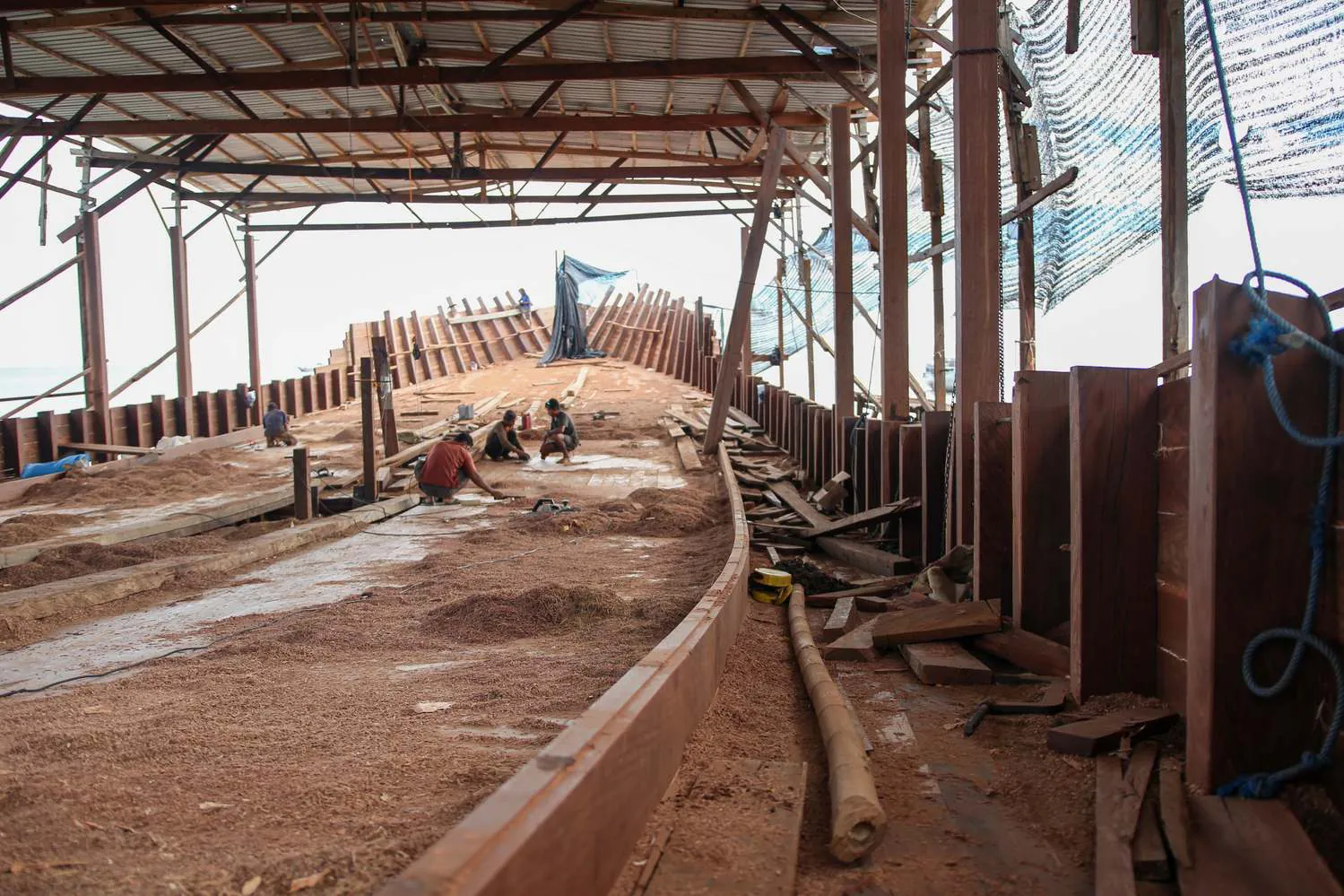 Craftsmen working on the long curved main deck of WAOW 2