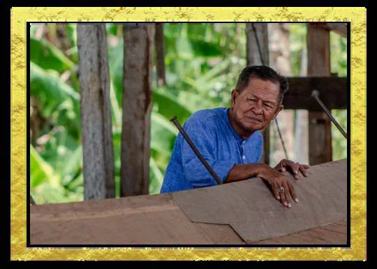A shipbuilder leaning on a wooden template at the shipyard, in a gold frame