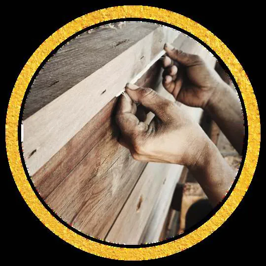 Close-up of hands working a piece of wood, in a round gold frame