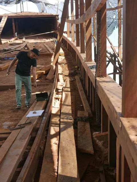 A craftsman walking along the main deck beside the new railing