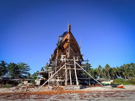 The hull of WAOW 2 in its wooden scaffolding against a deep blue sky