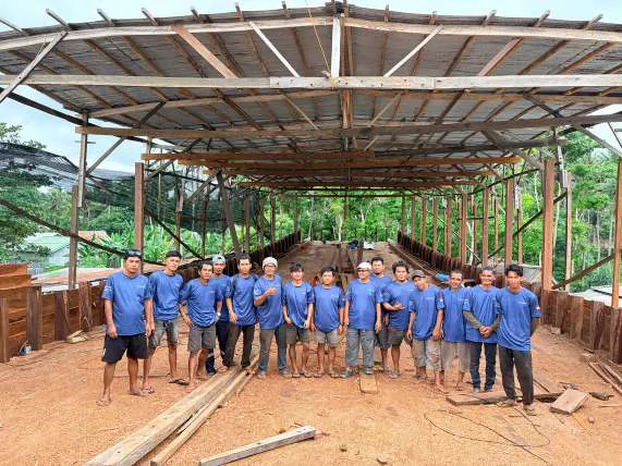 The shipyard crew in matching blue shirts lined up under the shipyard roof