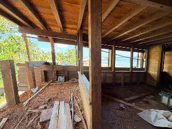 A room on the main deck taking shape, with window openings and stacked planks