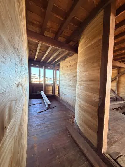 A narrow passage between wooden wall panels on the main deck