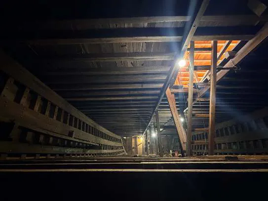 Dark view along the lower deck of WAOW 2 with a lit opening in the distance