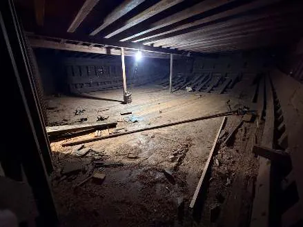 The bottom of the hull under the lower deck, lit by a single lamp