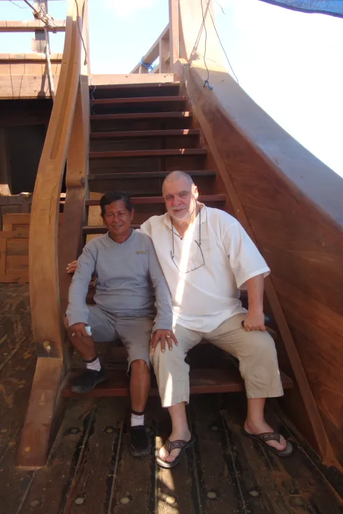 Michel Deville and a boatbuilder sitting on the stairs of WAOW.