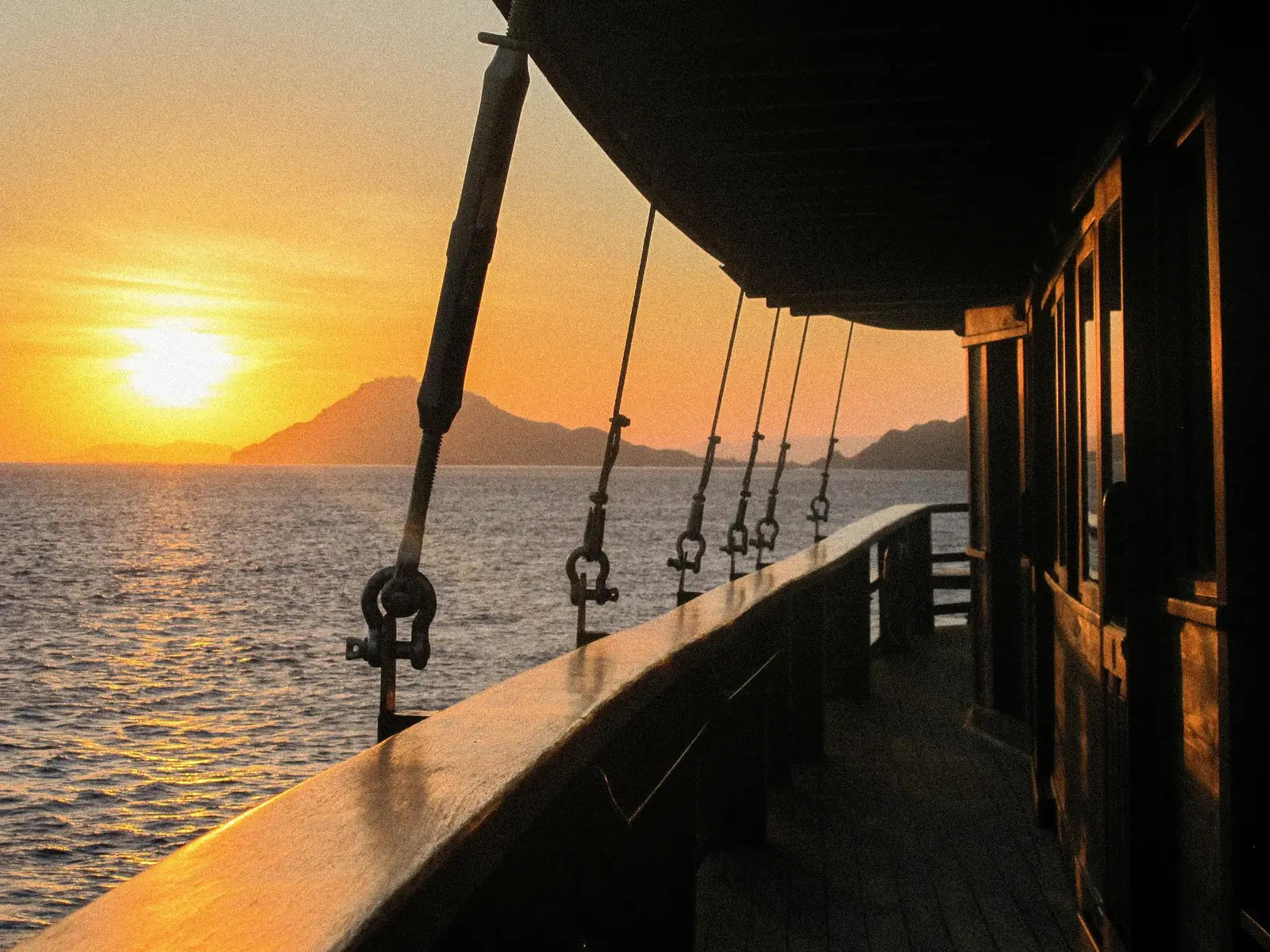 A guest stretching on deck at sunset.